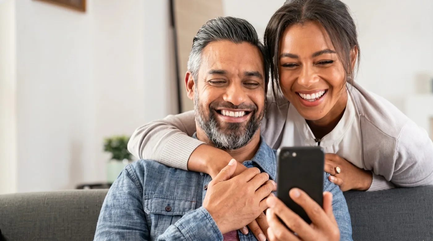 A couple smiling at a phone together